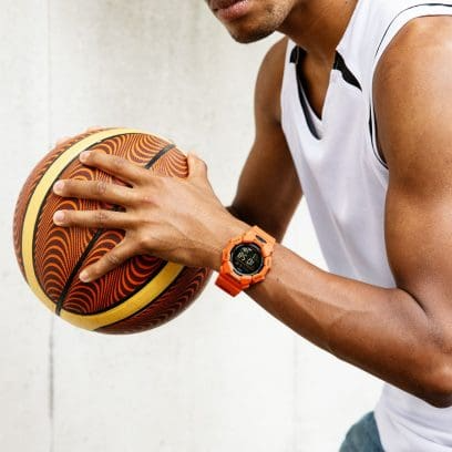 Reloj Casio G-Shock en muñeca de hombre en naranja.