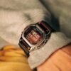 Reloj Casio G-Shock con bisel de acero inoxidable plateado con un acabado brillante, contrastando con la correa de resina negra.