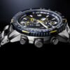 Reloj Citizen esfera azul con toques blancos y amarillos y exterior igual con correa plateada de acero inoxidable.