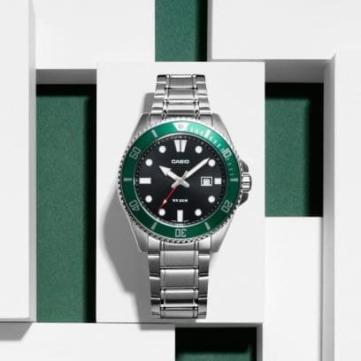 Reloj Casio con esfera negra y la carcasa de color verde mientras que la correa es plateada.